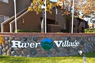 a sign with the river village logo on it in front of a house