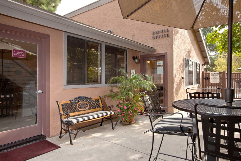 a patio with a table and chairs and a bench