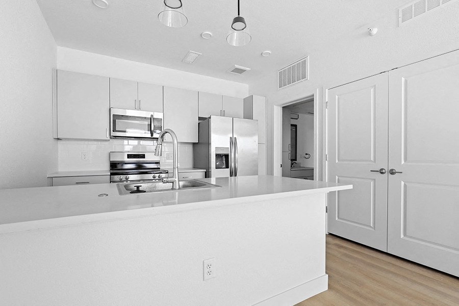 a large white kitchen with white cabinets and a white counter top