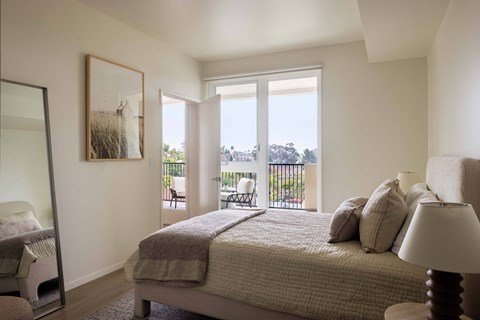 A bedroom with a large bed and a view of the outside.