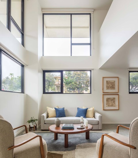 A living room with a couch, chairs, and a table.