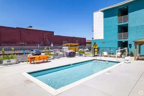 A pool area with a blue pool and a yellow chair.