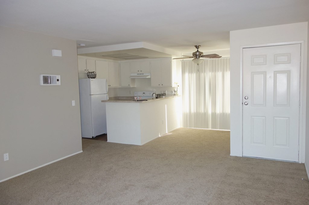 an open living room with a kitchen in the background