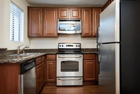 a kitchen with stainless steel appliances and wooden cabinets