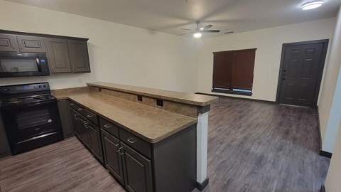 A kitchen with dark wood cabinets and a black oven.