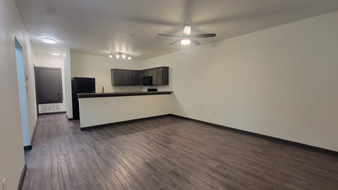 A spacious living room with a flat screen TV and a bar area.
