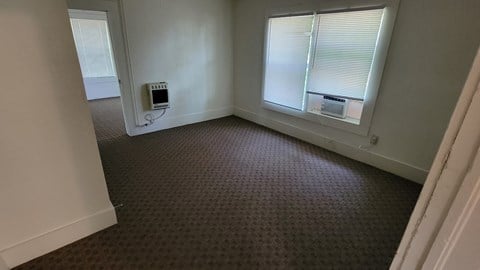 a living room with a window and a carpet