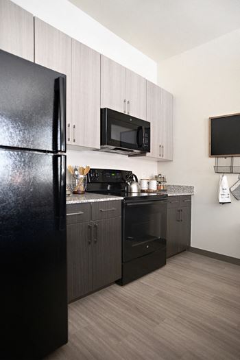a kitchen with black appliances and a black refrigerator at The Liberty Lofts, Gainesville, 76240