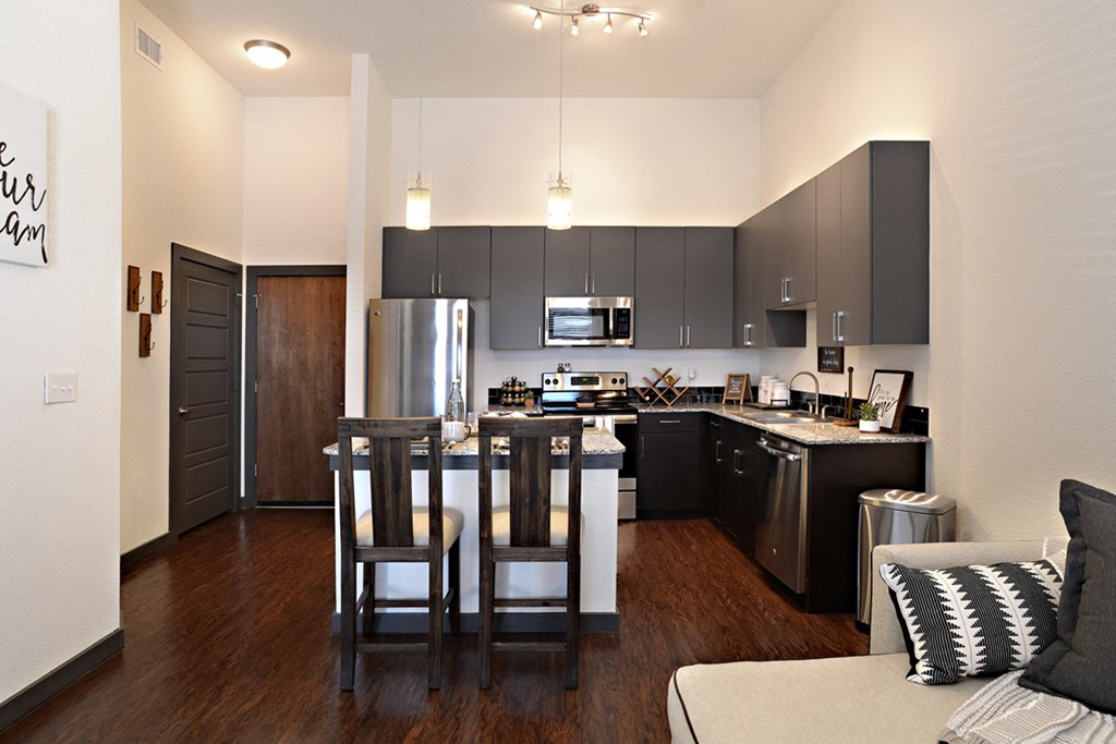 a view of a kitchen and a living room with a table and chairs