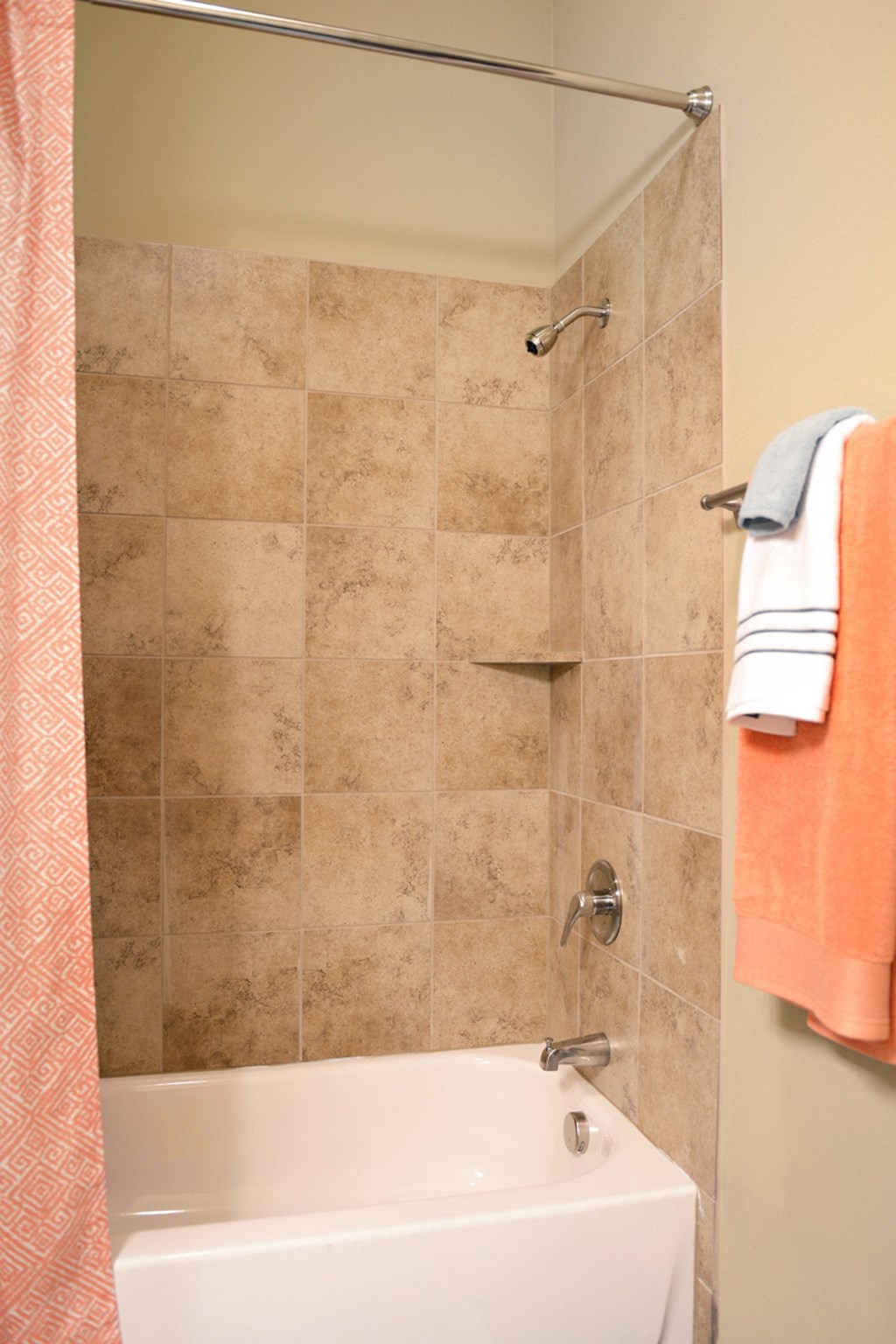 a bathroom with a shower and a tub and a towel
