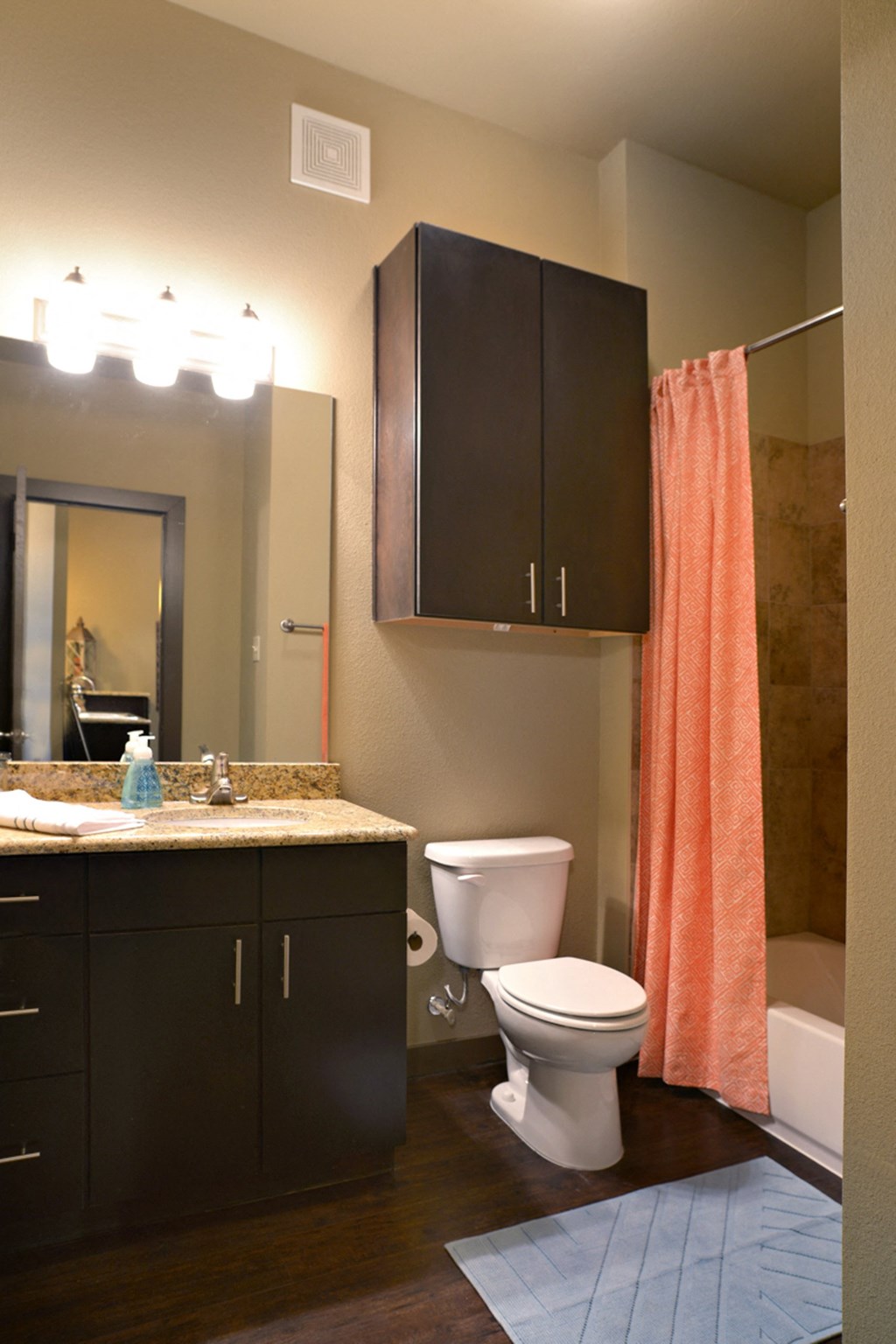 a bathroom with an orange shower curtain and a toilet and sink at Urban Square, Denton, TX, 76210