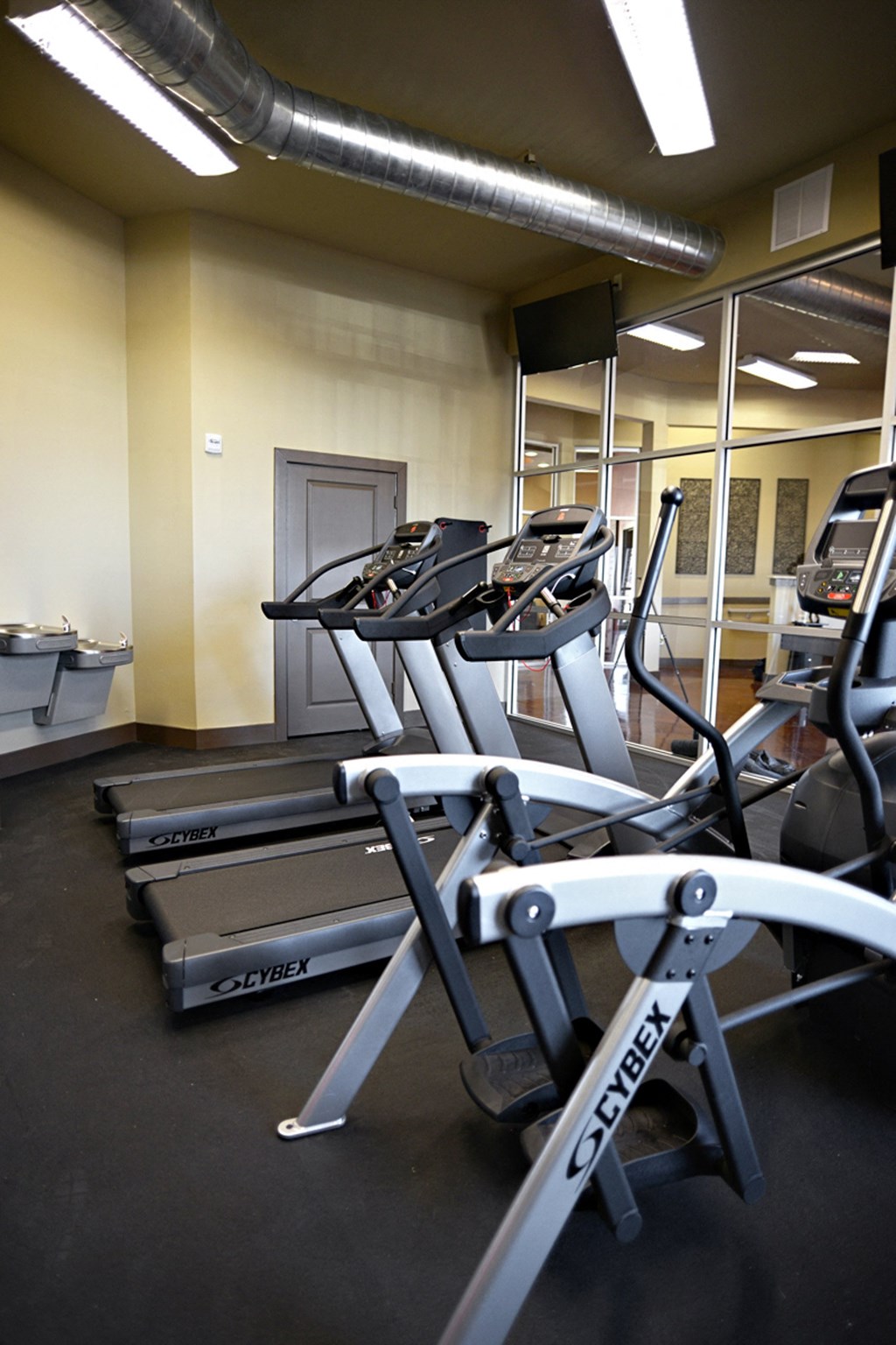 a gym with cardio equipment and weights in a building at Urban Square, Denton, Texas, 76210