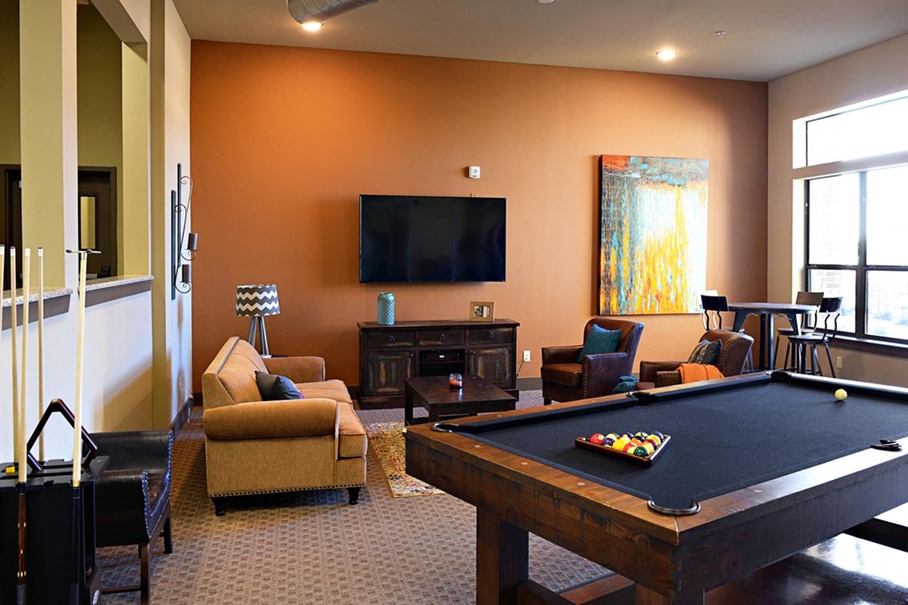 a living room with a pool table and a television at Urban Square, Denton, TX, 76210