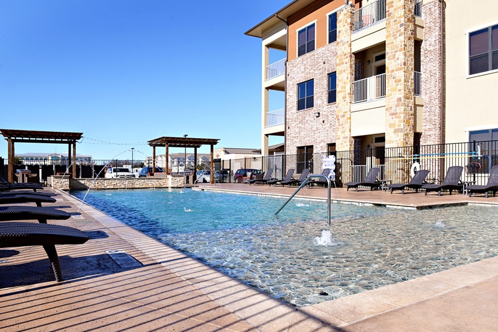 a swimming pool with a building in the background at Urban Square, Denton, Texas