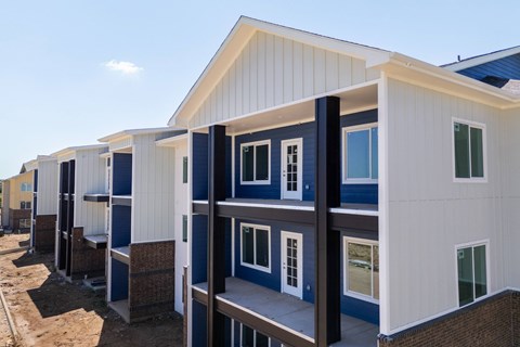 A series of white and blue prefabricated houses are lined up in a row.