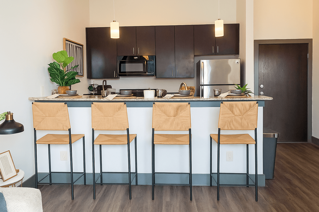 A kitchen with black cabinets and a blue island.