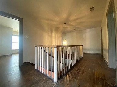 Beautiful wood stairs and railings an empty living room with a railing and a light