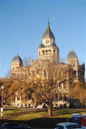 A large, ornate building with two towers and a clock on the front.