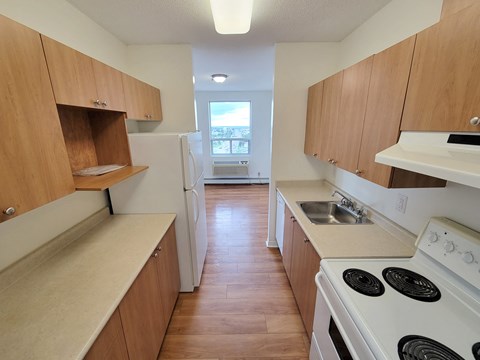 A kitchen with wooden cabinets and a white stove.