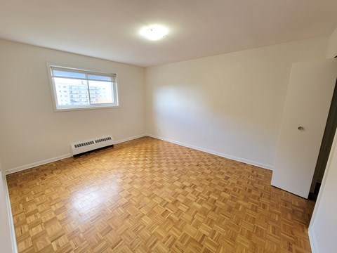 A room with a wooden floor and a window.