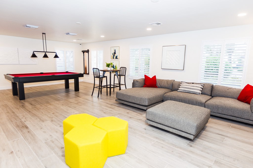 a living room with a pool table and couches