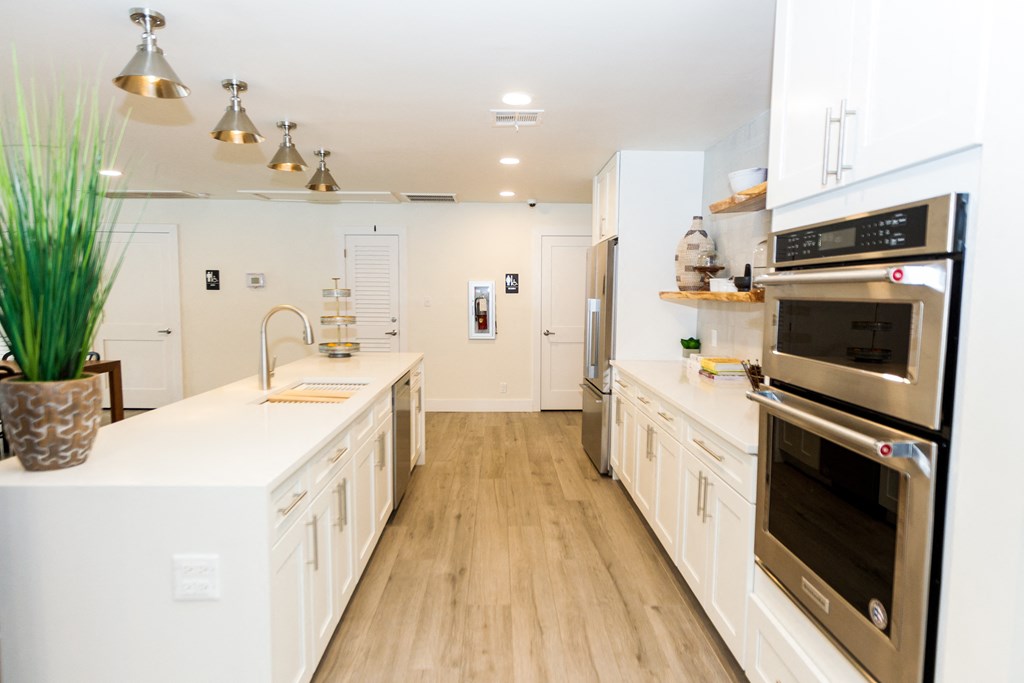 a large kitchen with white cabinets and stainless steel appliances