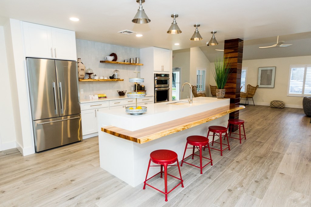 a kitchen with a large island and red bar stools