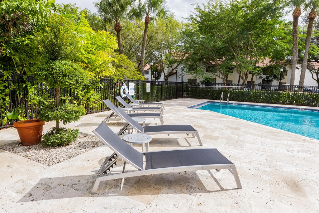 a group of lounge chairs sitting next to a swimming pool