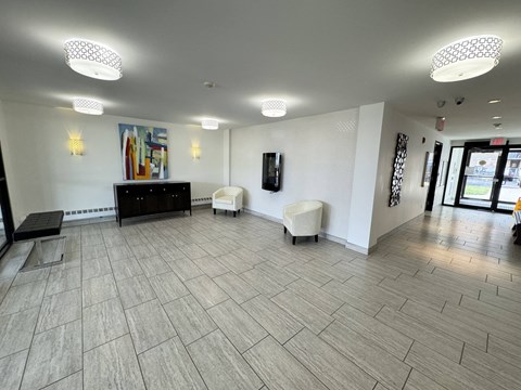 A spacious room with a wooden floor and white walls.