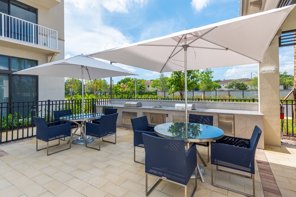 an outdoor patio with tables and chairs and umbrellas