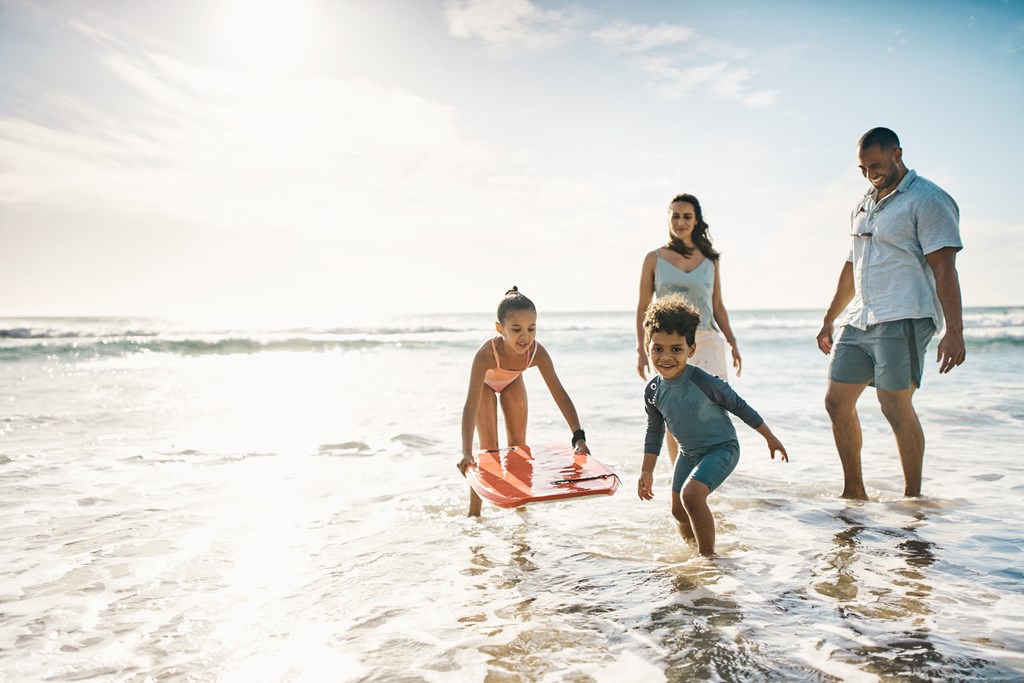 family playing in the water on the beach
