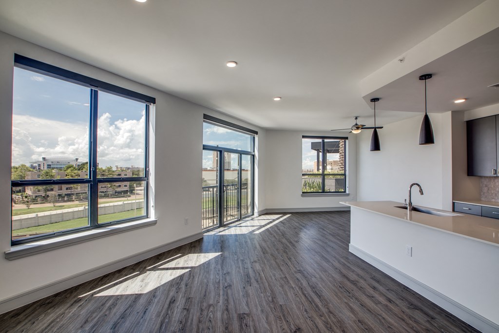 a kitchen and living room with large windows and a view of the city