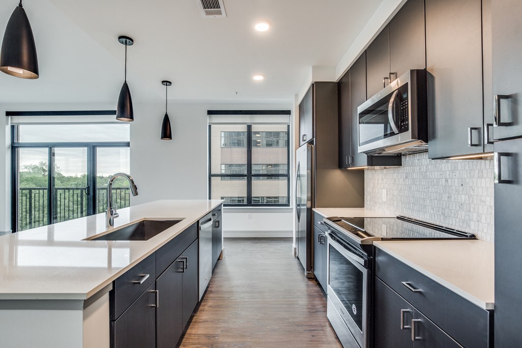 a kitchen with dark cabinets and white countertops