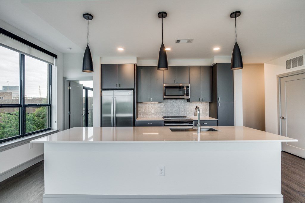 a kitchen with a large center island with a sink and a stove