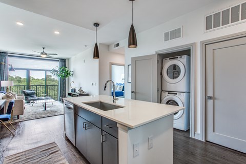 a kitchen with a sink and a washer and dryer in a house