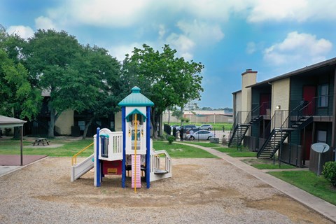 A playground with a slide and a playhouse.