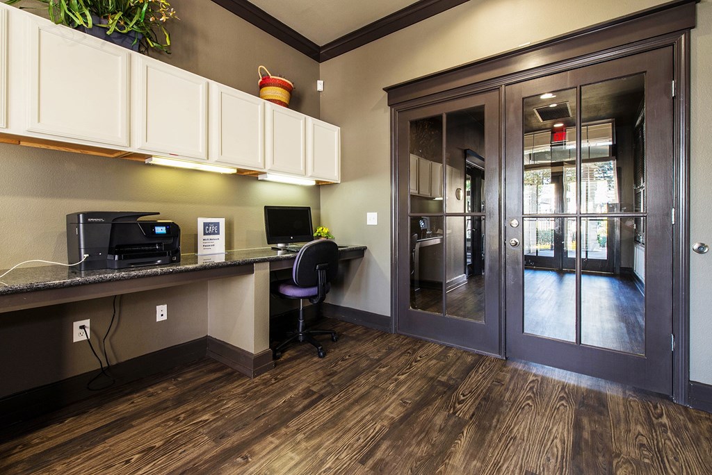 a lobby with a computer desk and a glass door