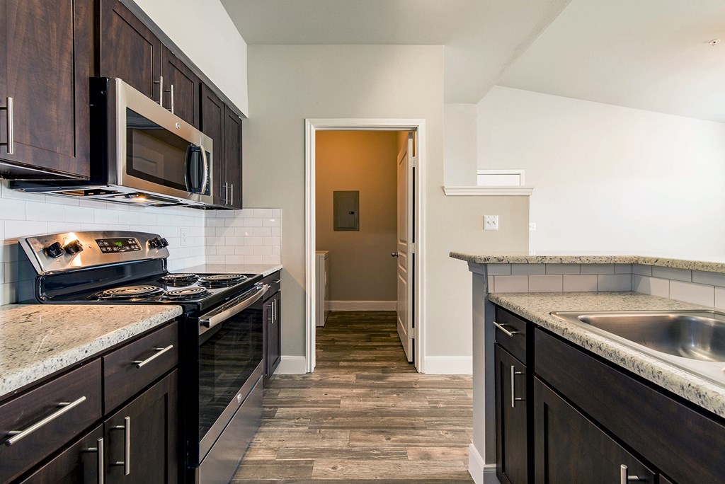 a kitchen with a stove and a sink and a microwave