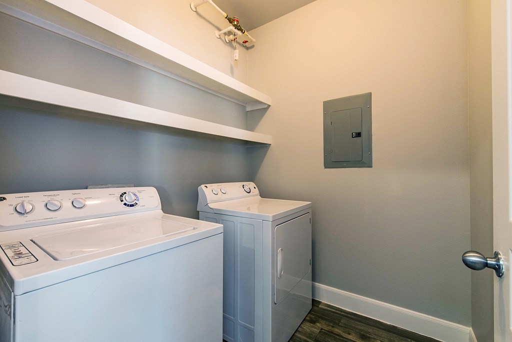 a laundry room with a washer and dryer in it and a white stove