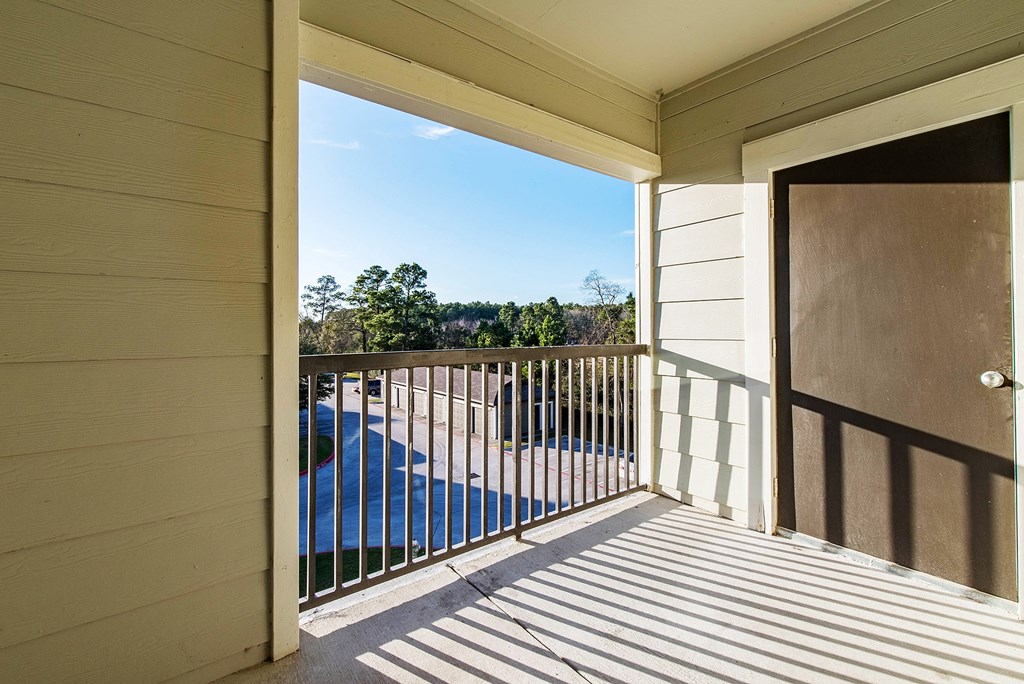 a balcony with a door and a view of a body of water