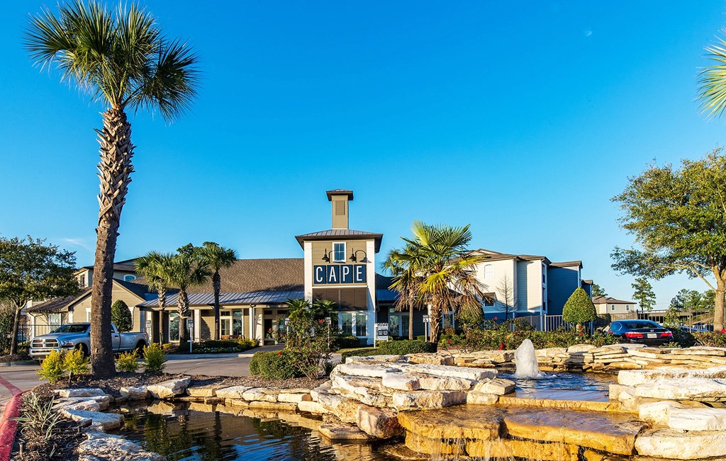 a fountain in front of a cafe with palm trees