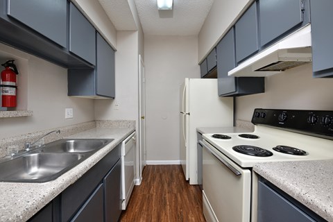 A kitchen with a white stove and a white refrigerator.