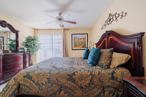 A bedroom with a large bed and a ceiling fan.