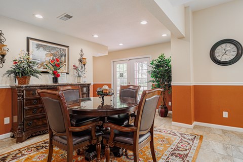 A dining room with a table set for four.