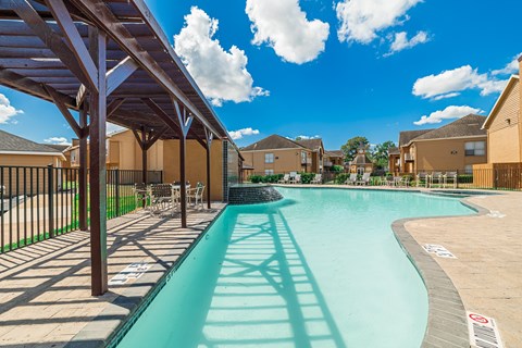 A swimming pool with a slide and a fence.