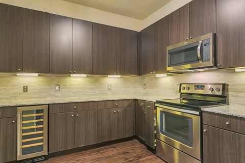A modern kitchen with dark wood cabinets and stainless steel appliances.