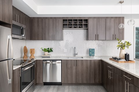 A modern kitchen with dark wood cabinets and stainless steel appliances.