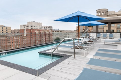 A blue umbrella shades a pool area.