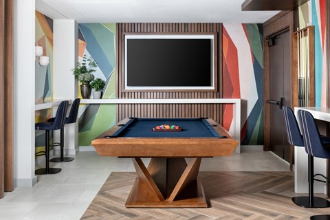 A pool table with a television above it in a room.