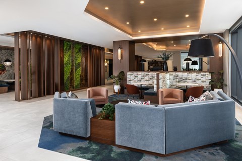 A modern living room with a grey sofa and a wooden floor.